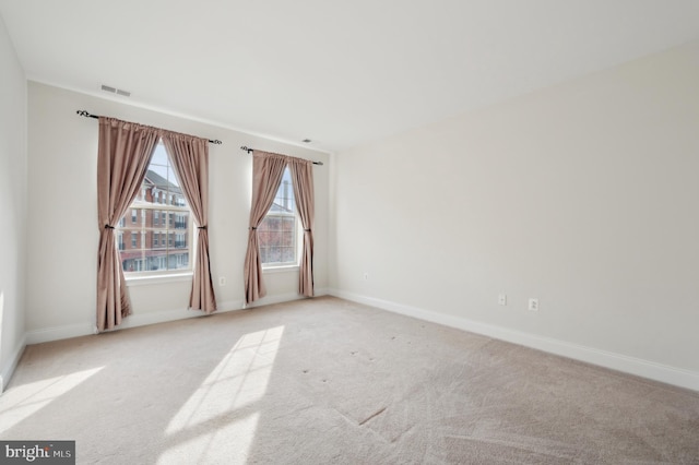 unfurnished room featuring light carpet