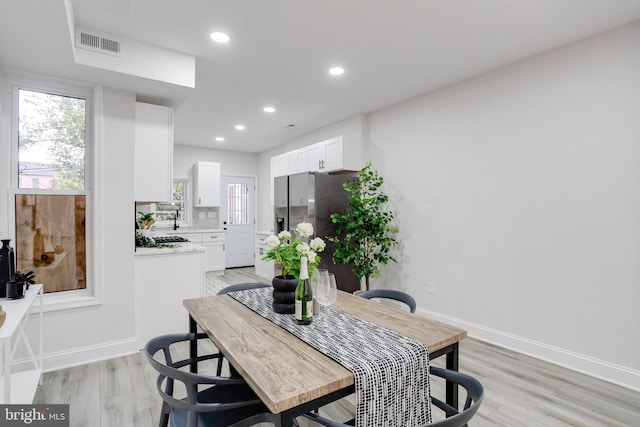 dining area with sink and light wood-type flooring