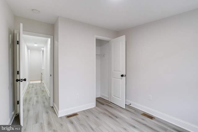 unfurnished bedroom featuring a closet and light hardwood / wood-style floors