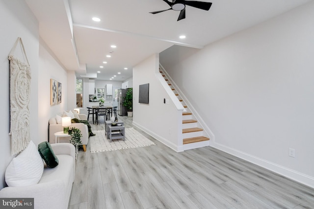 living room with light hardwood / wood-style flooring and ceiling fan