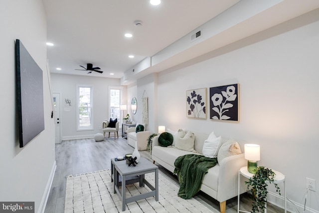 living room featuring light wood-type flooring and ceiling fan