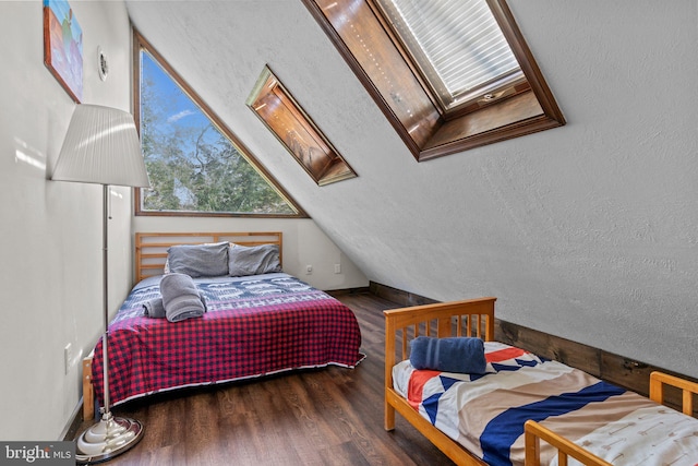 bedroom featuring vaulted ceiling with skylight and dark hardwood / wood-style flooring