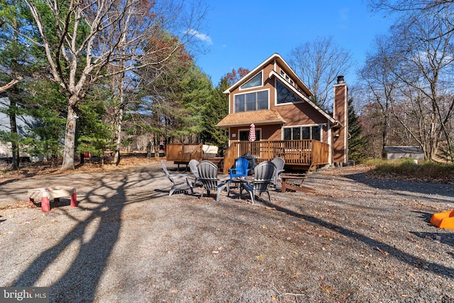 exterior space featuring an outdoor fire pit and a deck