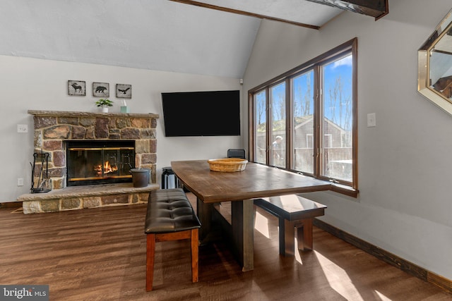 dining room featuring wood-type flooring, a fireplace, and vaulted ceiling