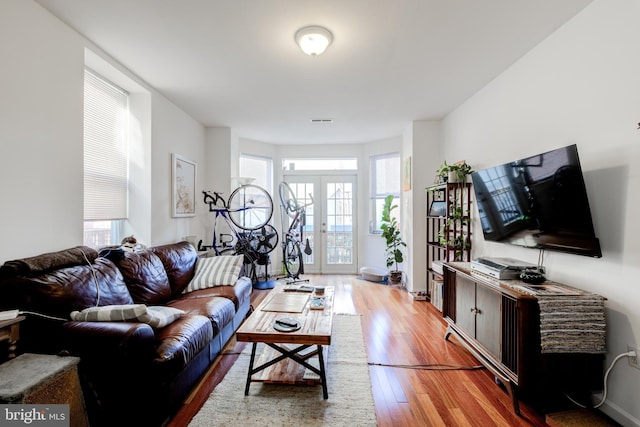 living room featuring french doors and light wood-type flooring