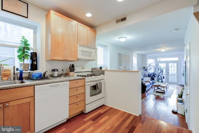 kitchen featuring light brown cabinetry, sink, dark hardwood / wood-style floors, and white appliances