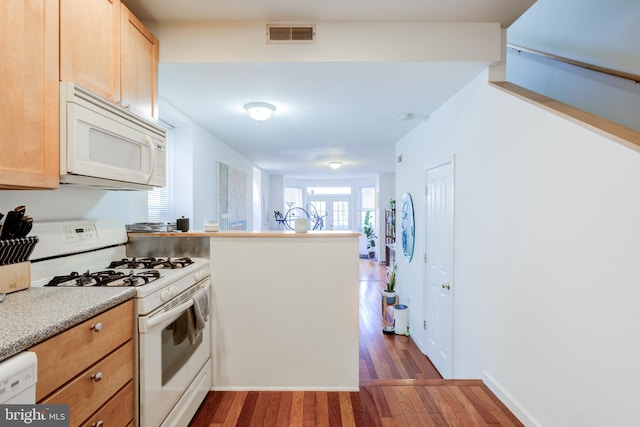 kitchen featuring white appliances, dark hardwood / wood-style flooring, and light brown cabinets