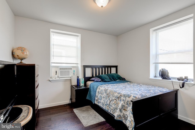 bedroom featuring multiple windows, cooling unit, and dark hardwood / wood-style flooring