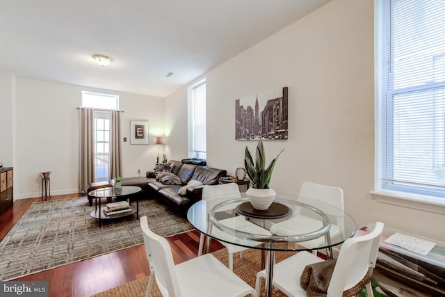 dining space with hardwood / wood-style flooring and a healthy amount of sunlight