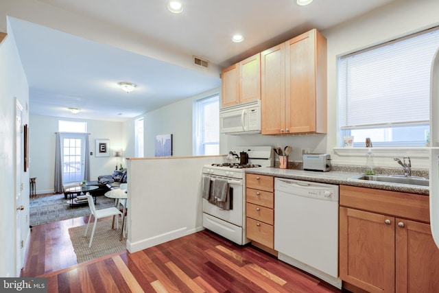 kitchen with white appliances, sink, light brown cabinets, and dark hardwood / wood-style floors