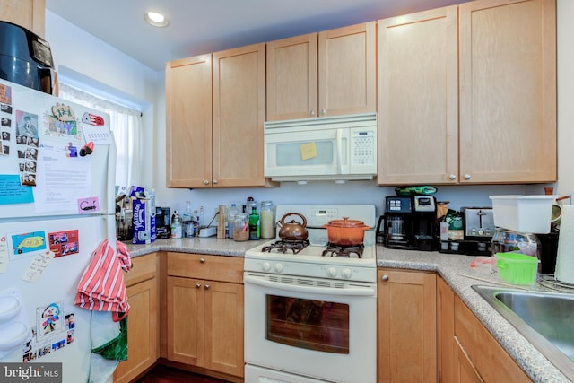 kitchen with white appliances, sink, and light brown cabinets