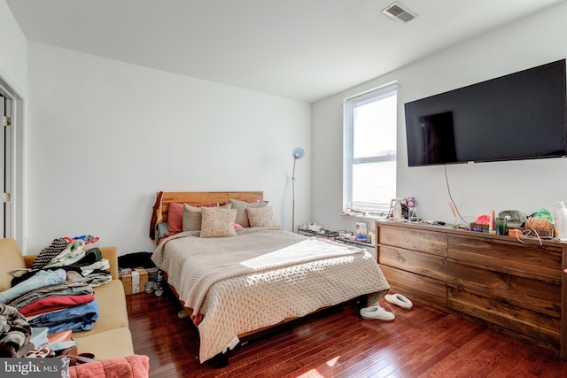 bedroom with dark hardwood / wood-style floors