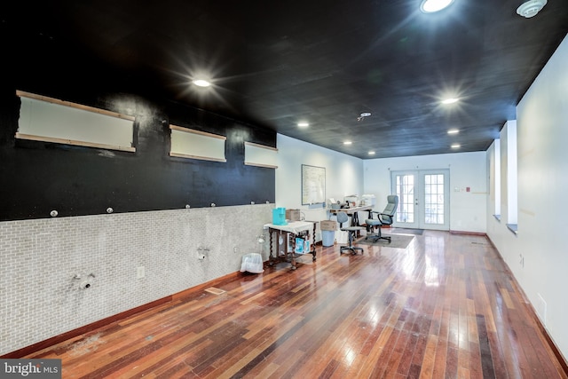 misc room featuring french doors, tile walls, and wood-type flooring