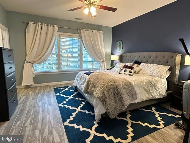 bedroom with ceiling fan and wood-type flooring