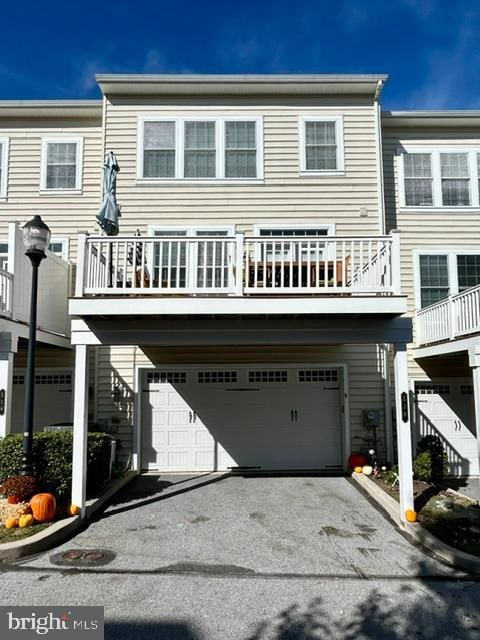 back of house with a balcony and a garage