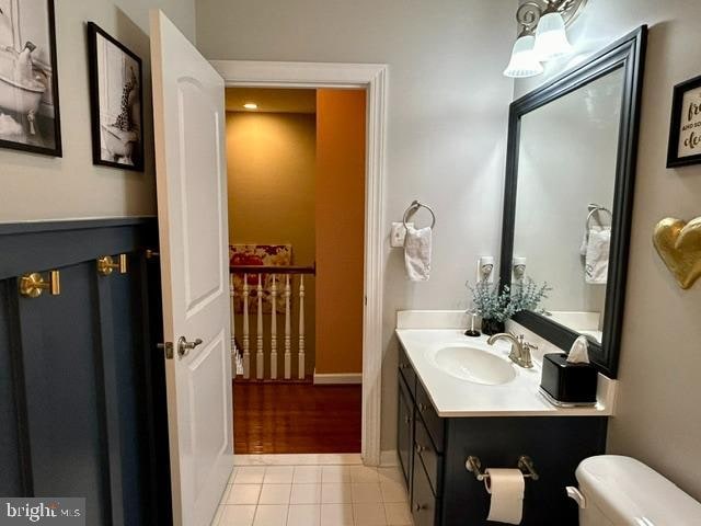 bathroom with tile patterned flooring, vanity, and toilet