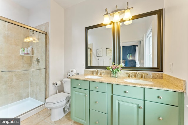 bathroom with tile patterned floors, vanity, a shower with shower door, and toilet