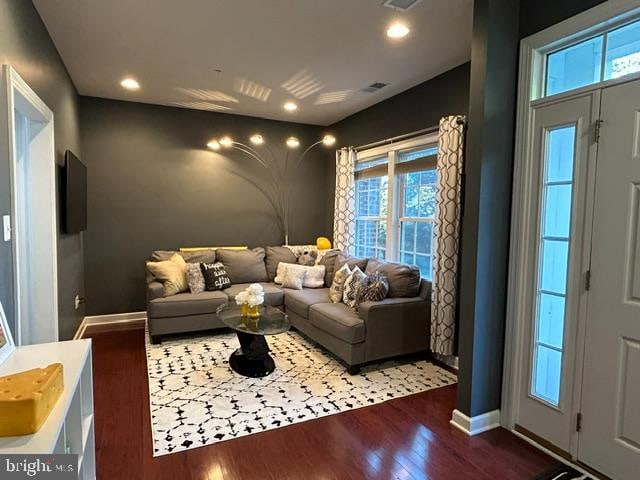 home theater room with dark wood-type flooring and a wealth of natural light