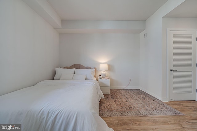 bedroom featuring wood-type flooring and a closet