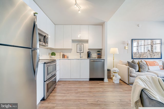 kitchen featuring sink, appliances with stainless steel finishes, light hardwood / wood-style flooring, and white cabinets