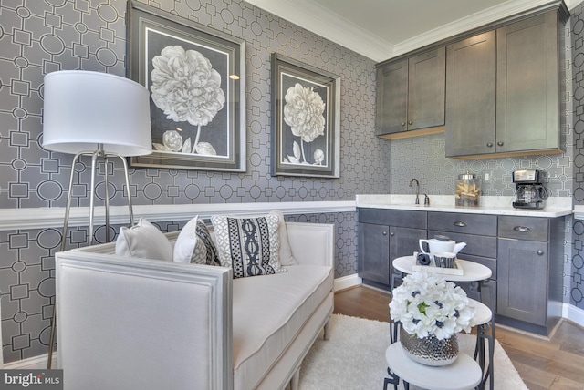 sitting room featuring ornamental molding, hardwood / wood-style floors, and sink