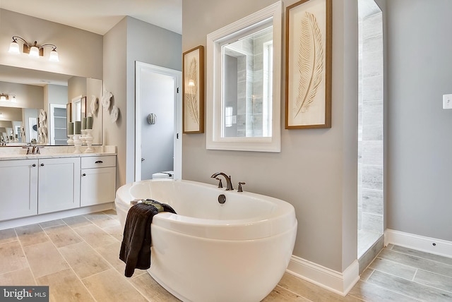 12412 Lusbys Ln, Brandywine, MD 20613 - bathroom with a freestanding bath, toilet, baseboards, and vanity