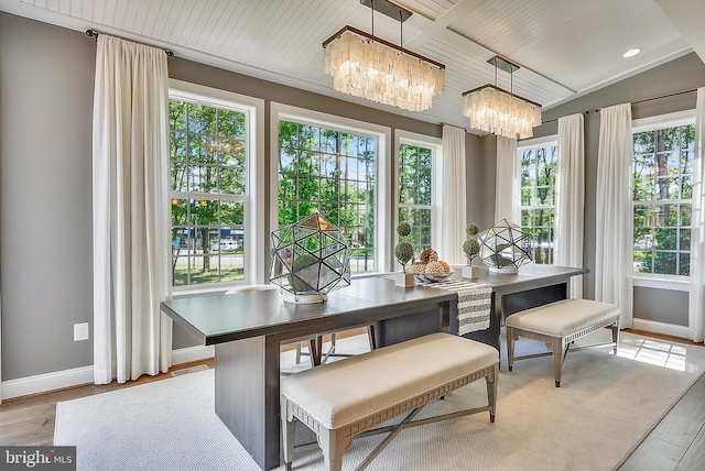 dining space with light hardwood / wood-style floors, lofted ceiling, plenty of natural light, and a chandelier