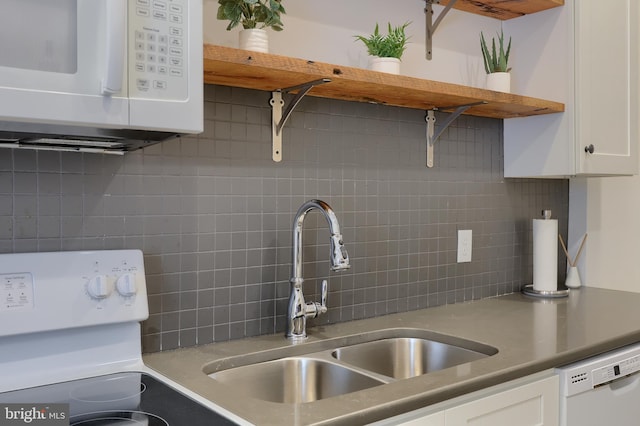 kitchen featuring white cabinets, sink, white appliances, and backsplash