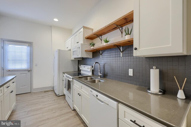 kitchen featuring decorative backsplash, white appliances, and white cabinetry