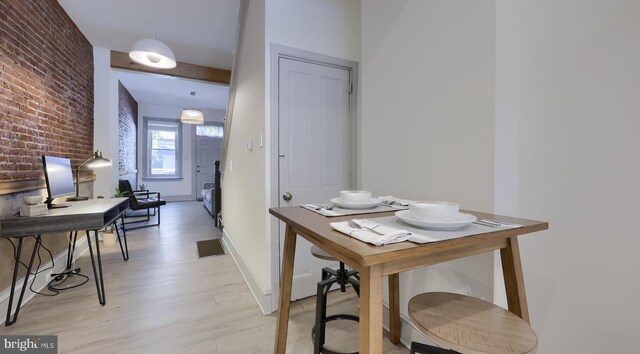 interior space featuring light wood-type flooring and brick wall