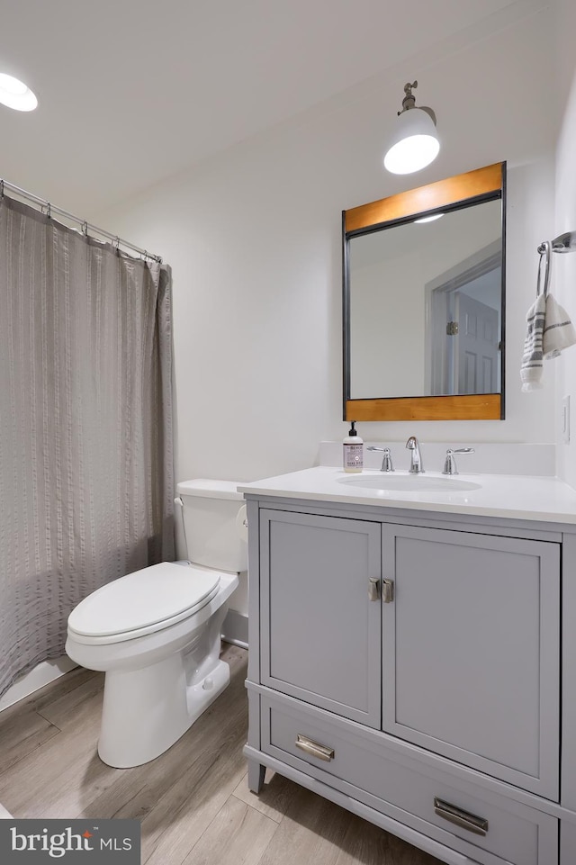 bathroom featuring hardwood / wood-style floors, vanity, and toilet