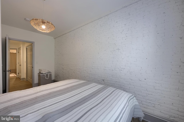 unfurnished bedroom featuring brick wall