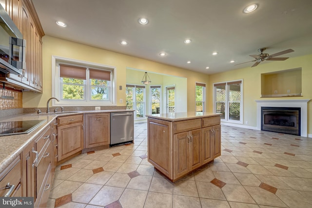 kitchen with sink, plenty of natural light, a kitchen island, and appliances with stainless steel finishes