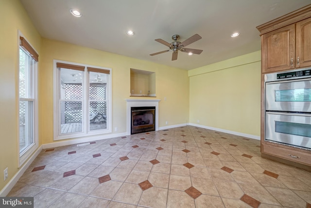 unfurnished living room with ceiling fan and light tile patterned flooring