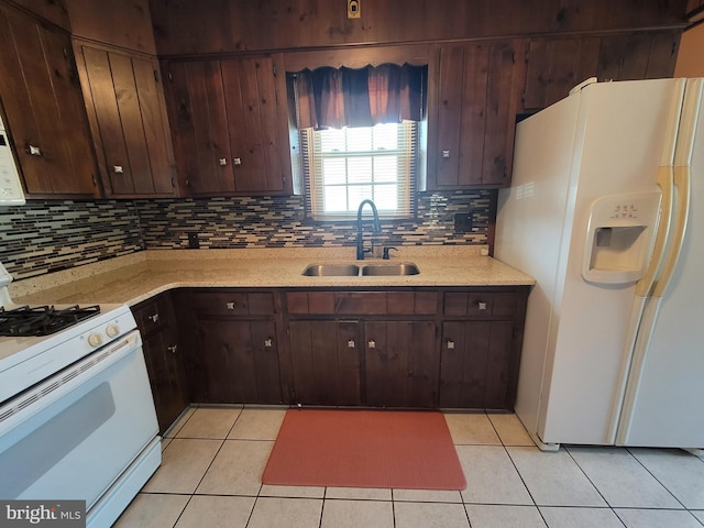 kitchen with sink, light tile patterned floors, backsplash, and white appliances