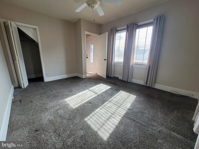 interior space with ceiling fan and dark colored carpet