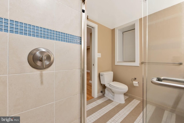 bathroom featuring tile patterned floors, toilet, and walk in shower