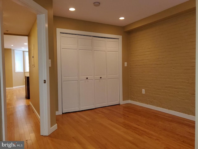 unfurnished bedroom with light wood-type flooring and a closet