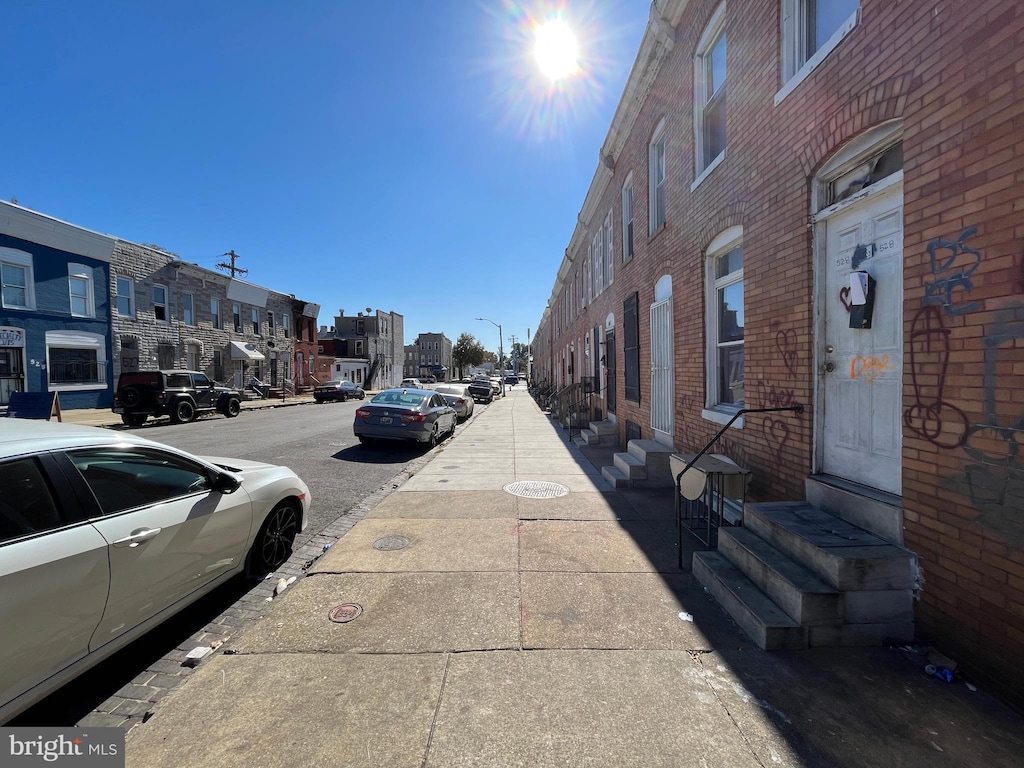 view of street with street lights, a residential view, sidewalks, entry steps, and curbs