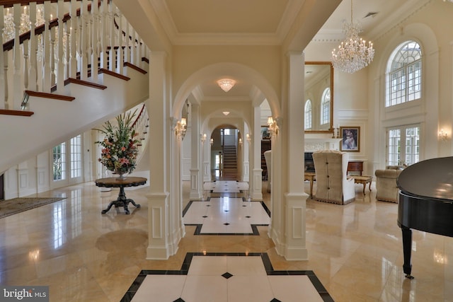 foyer with a wealth of natural light, a high ceiling, french doors, and ornamental molding