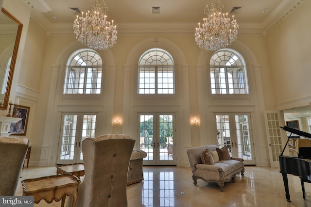 living room featuring a high ceiling, crown molding, french doors, and a notable chandelier