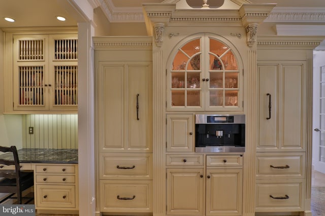 interior space featuring crown molding, cream cabinets, and stainless steel oven