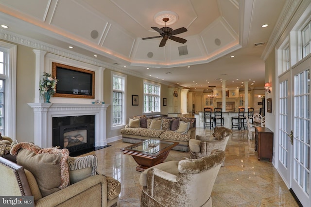 living room with a wealth of natural light, ceiling fan, and ornamental molding