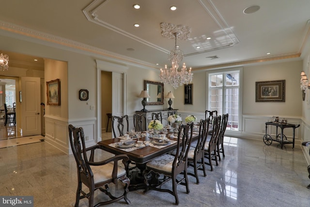 dining space with a notable chandelier, crown molding, and a raised ceiling