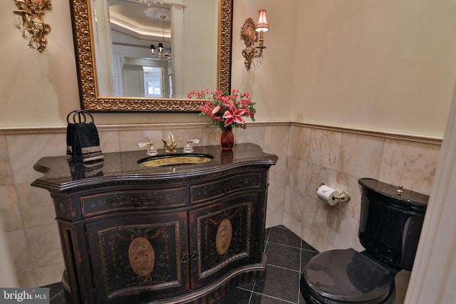 bathroom with vanity, toilet, tile walls, and ornamental molding