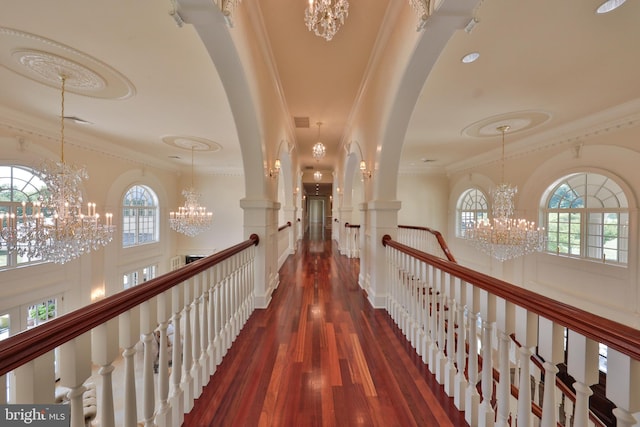 corridor featuring dark wood-type flooring, a wealth of natural light, and crown molding