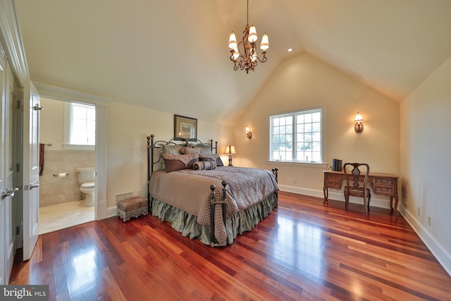 bedroom with ensuite bath, a notable chandelier, hardwood / wood-style flooring, and lofted ceiling