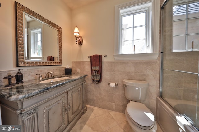 full bathroom featuring tile walls, bath / shower combo with glass door, toilet, and tile patterned flooring