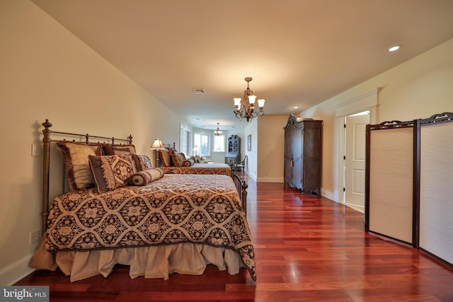 bedroom featuring an inviting chandelier and hardwood / wood-style floors