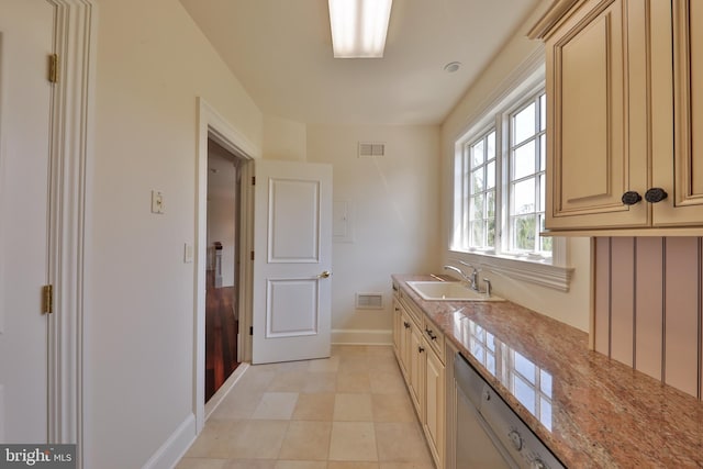 kitchen with stainless steel dishwasher, light stone countertops, sink, and light tile patterned flooring